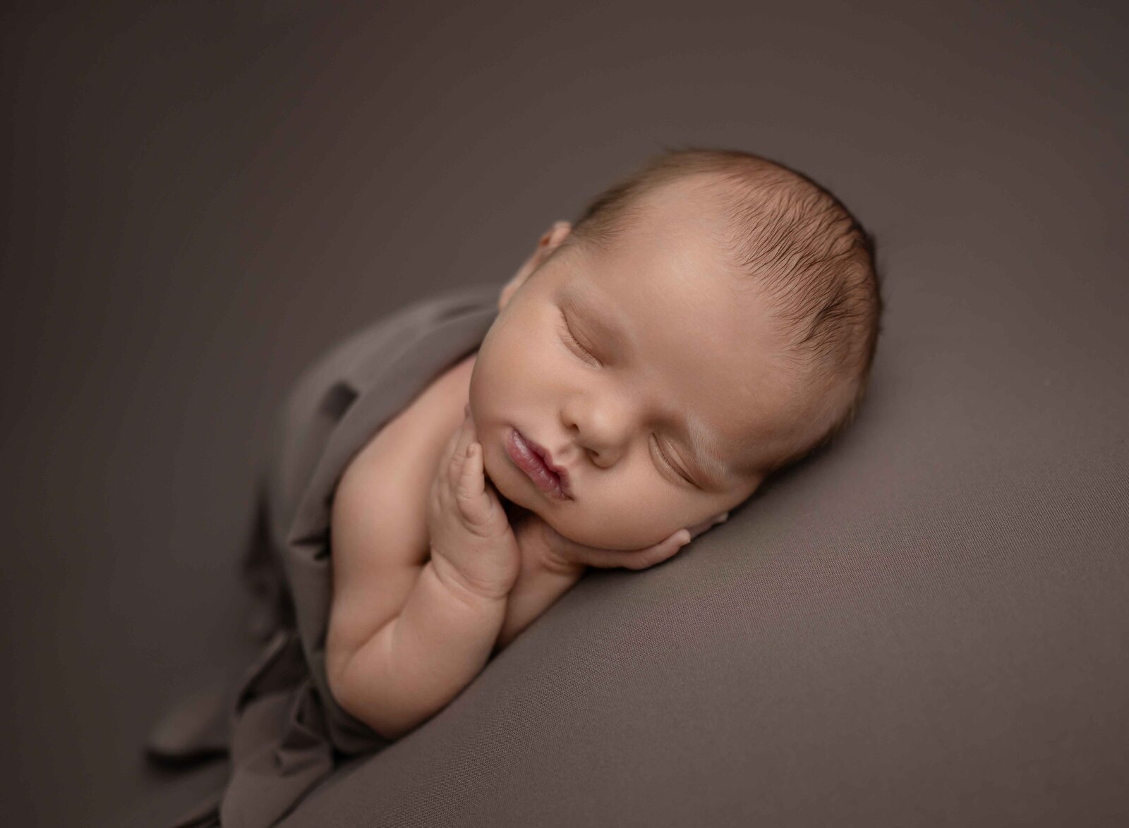 baby sleeping on tummy with hands touching cheeks sweetly. Photographed by Atlanta baby photographer.