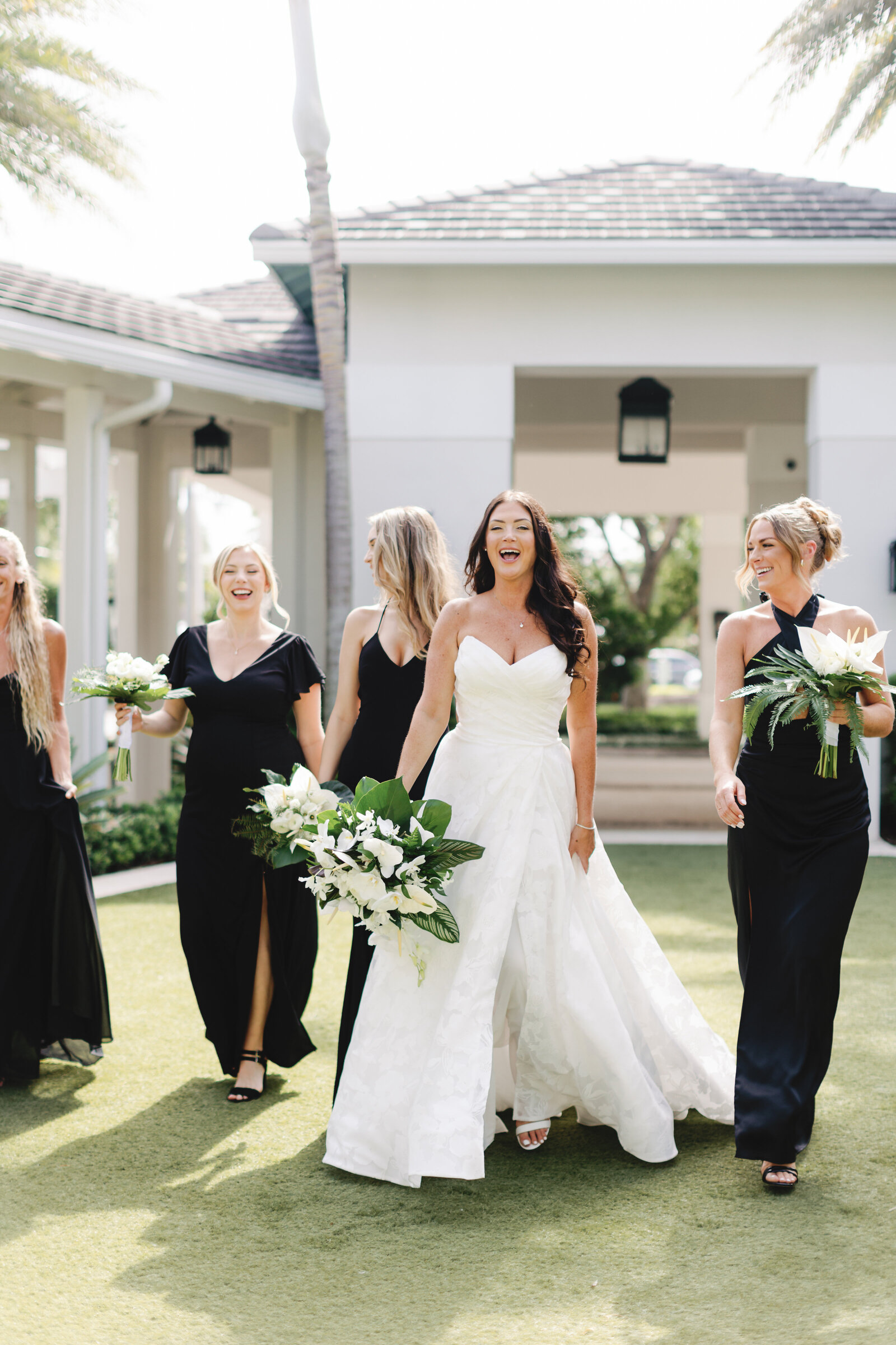 Bride and her Bridesmaids walking in the courtyard of The Pelican Club in Jupiter, Florida. Photo by Maggie Alvarez Photography