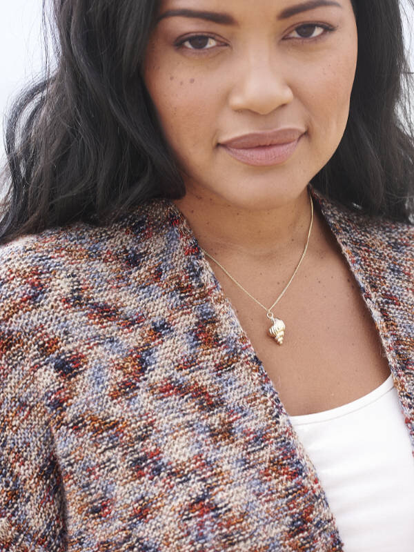 Natural makeup for a model wearing a sweater and shell necklace