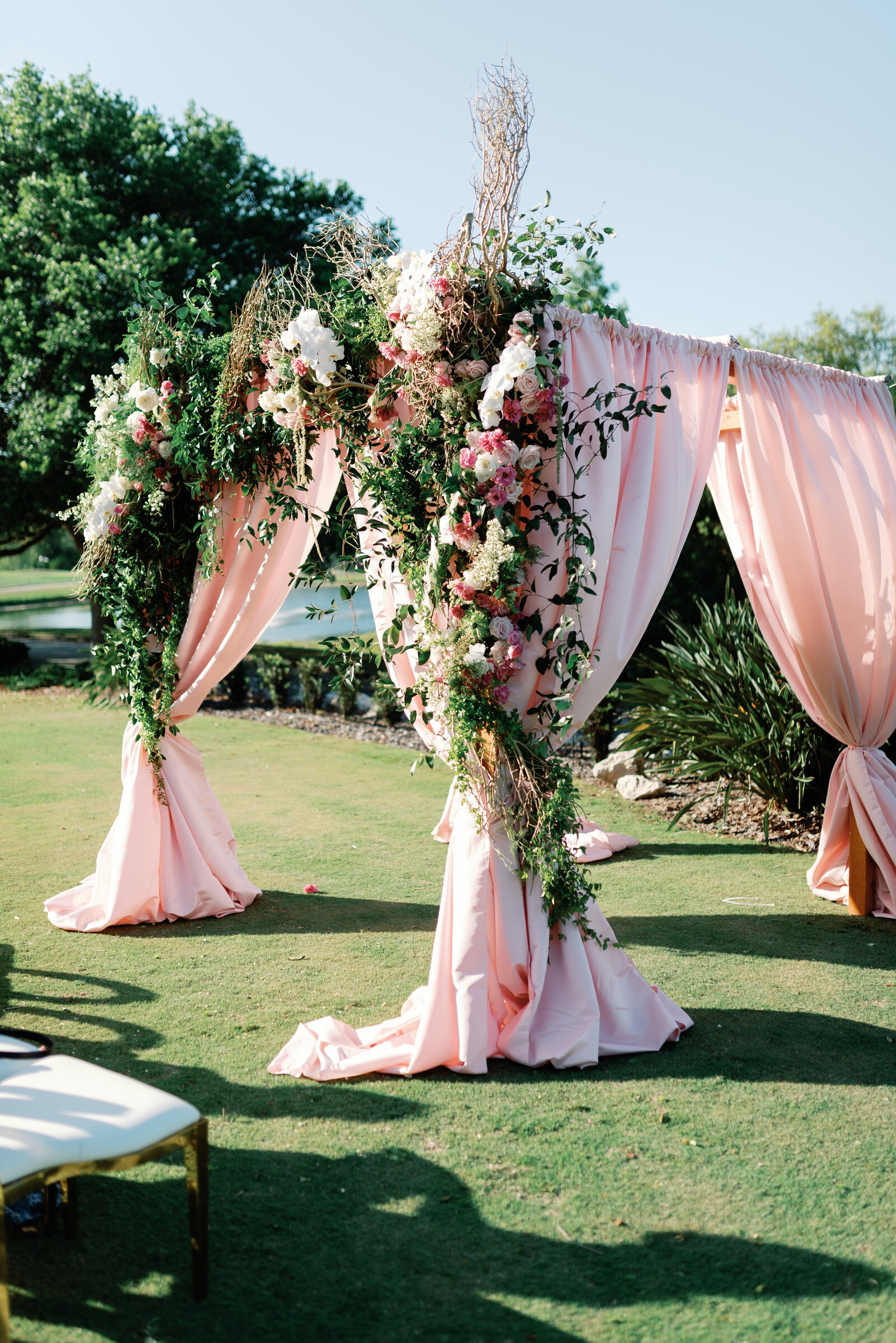 Pink drapery and florals decorating a wedding day altar