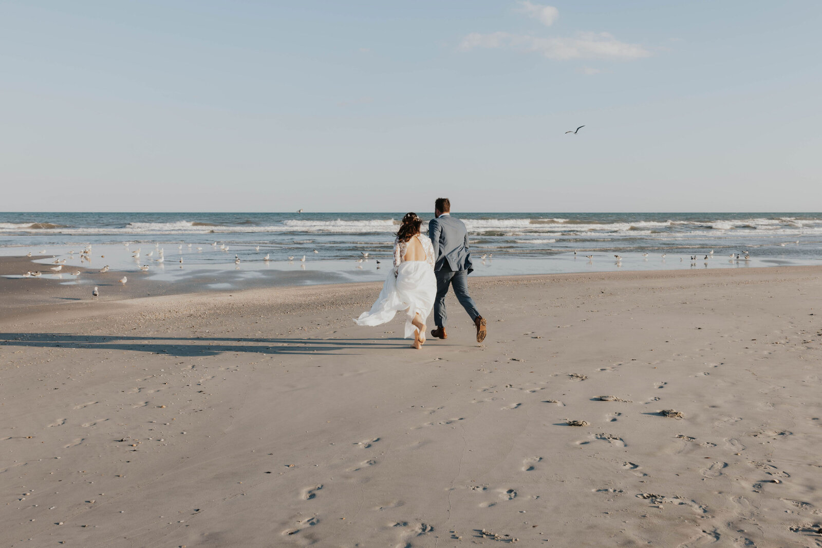 newlyweds running on beach