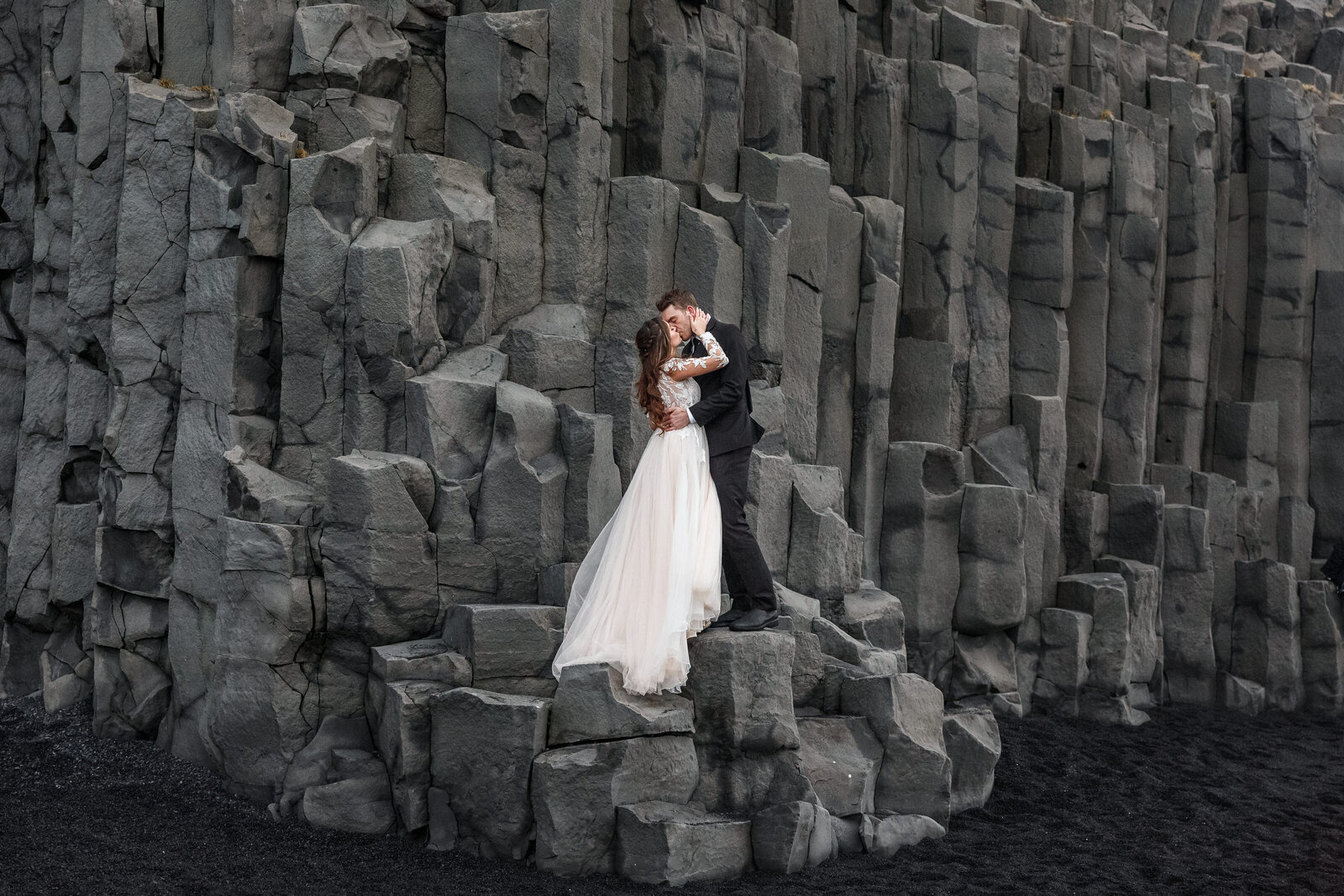 eloping couple kissing on an iceland black sand beach