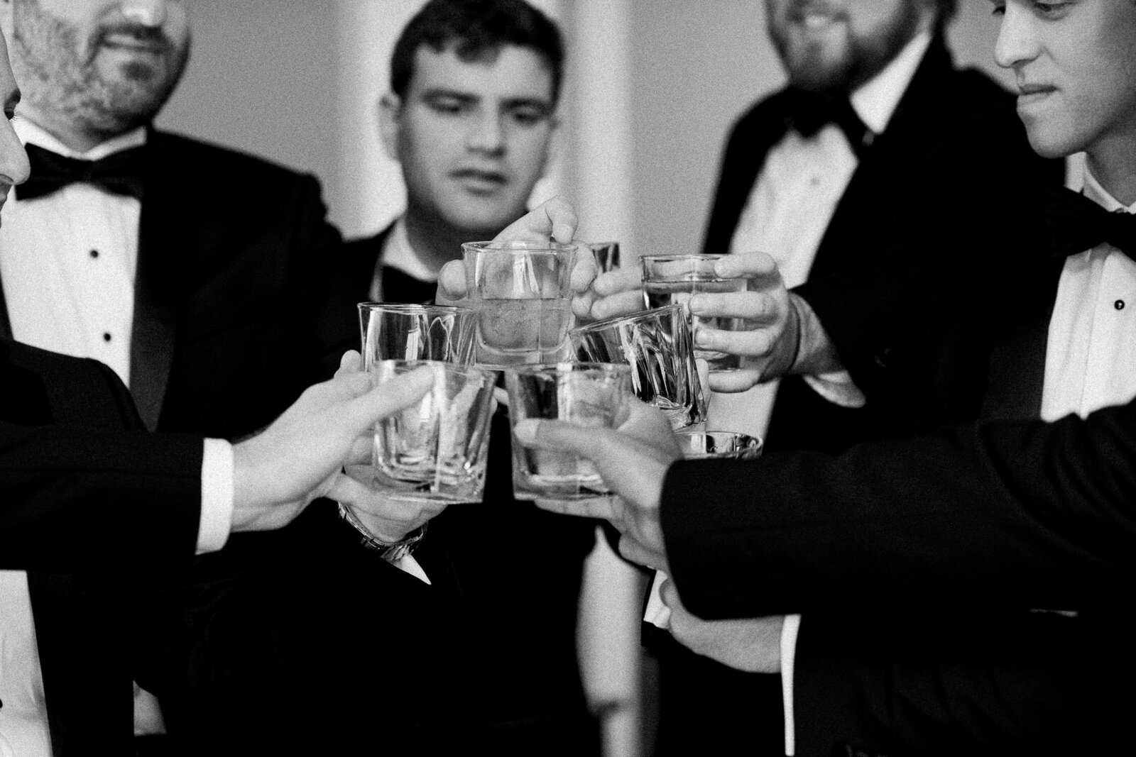 closeup of toast glasses with groomsmen