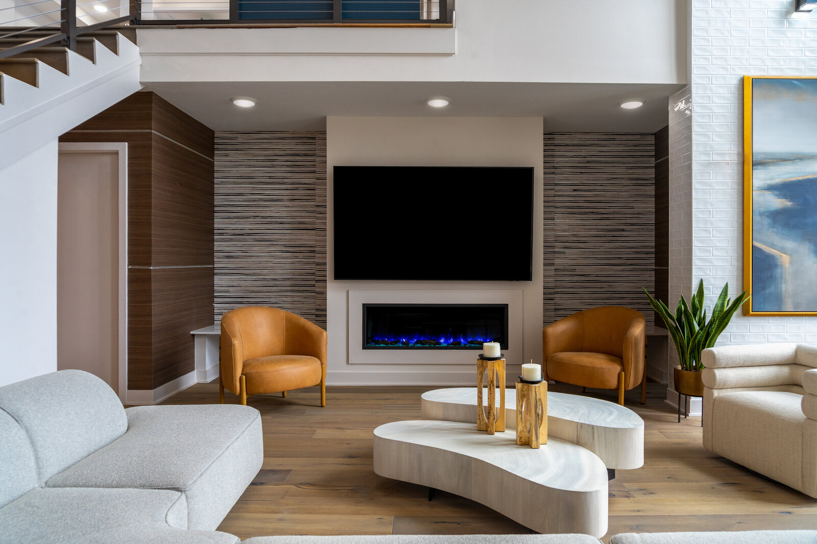 Modern Luxury Living Room Design with Curved Sofas, Leather Accent Chairs, and Electric Fireplace Feature Wall