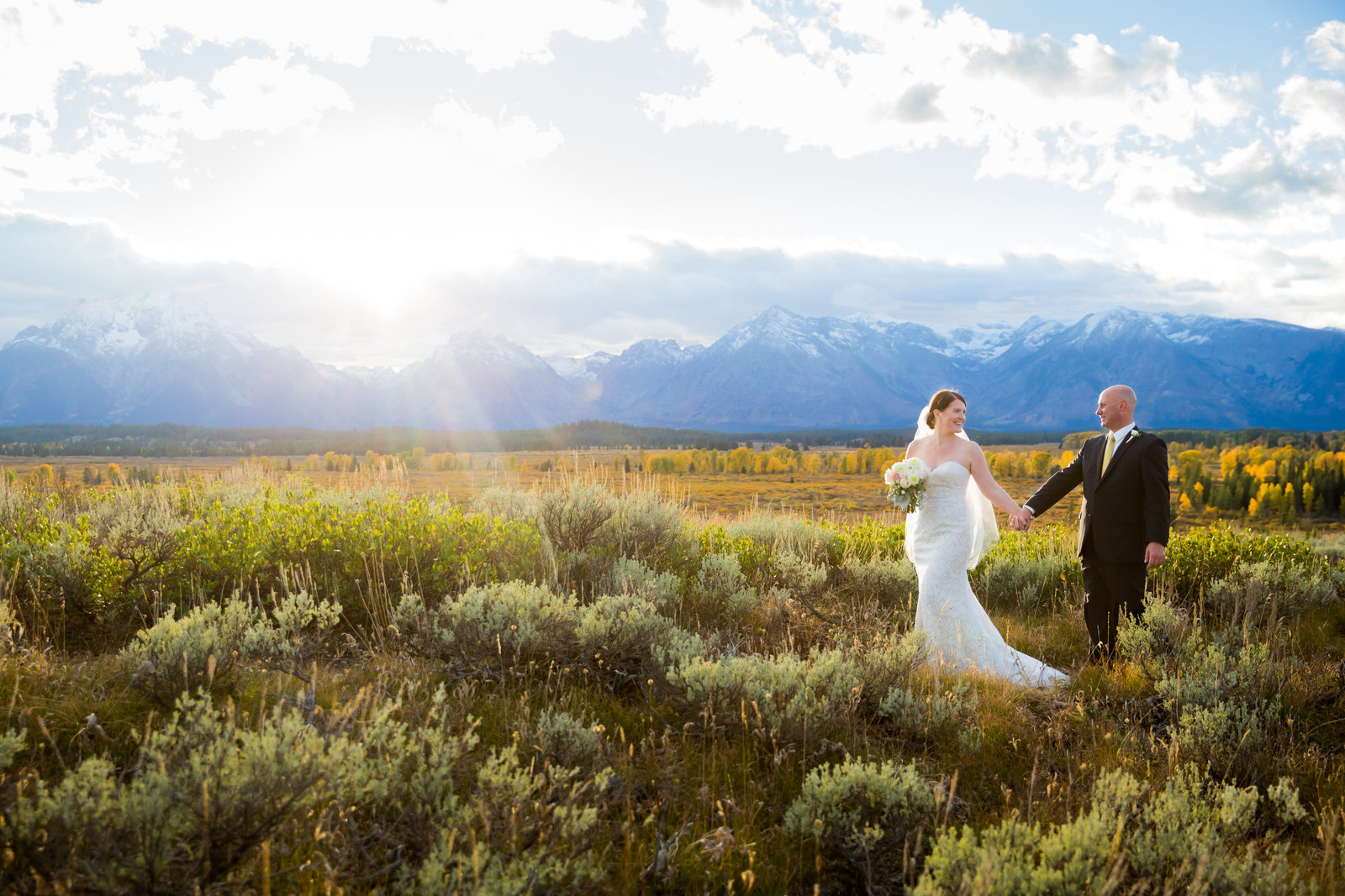 Bride and Groom walking at sunset at Jackson Lake Lodge