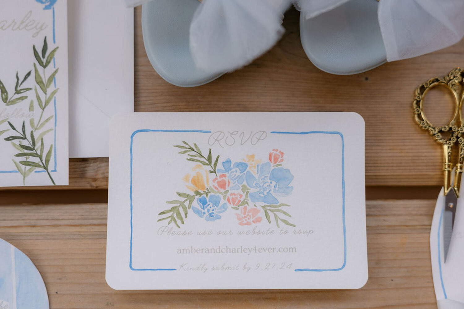 Close-up of RSVP card with floral watercolor details and blue accents