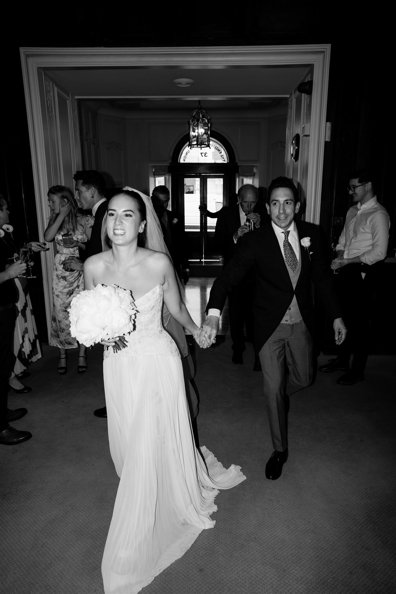 Happy bride and groom entering Dartmouth House for their wedding 
