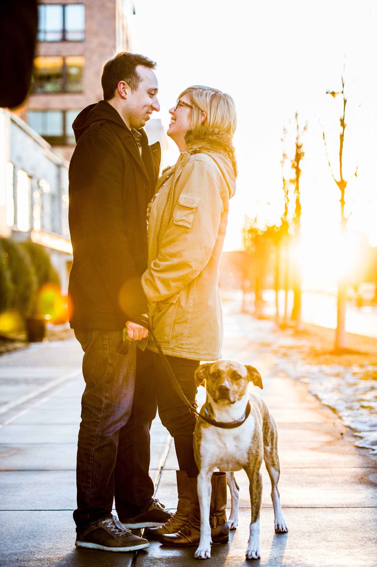Man and woman with their dog at sunrise engagement photography