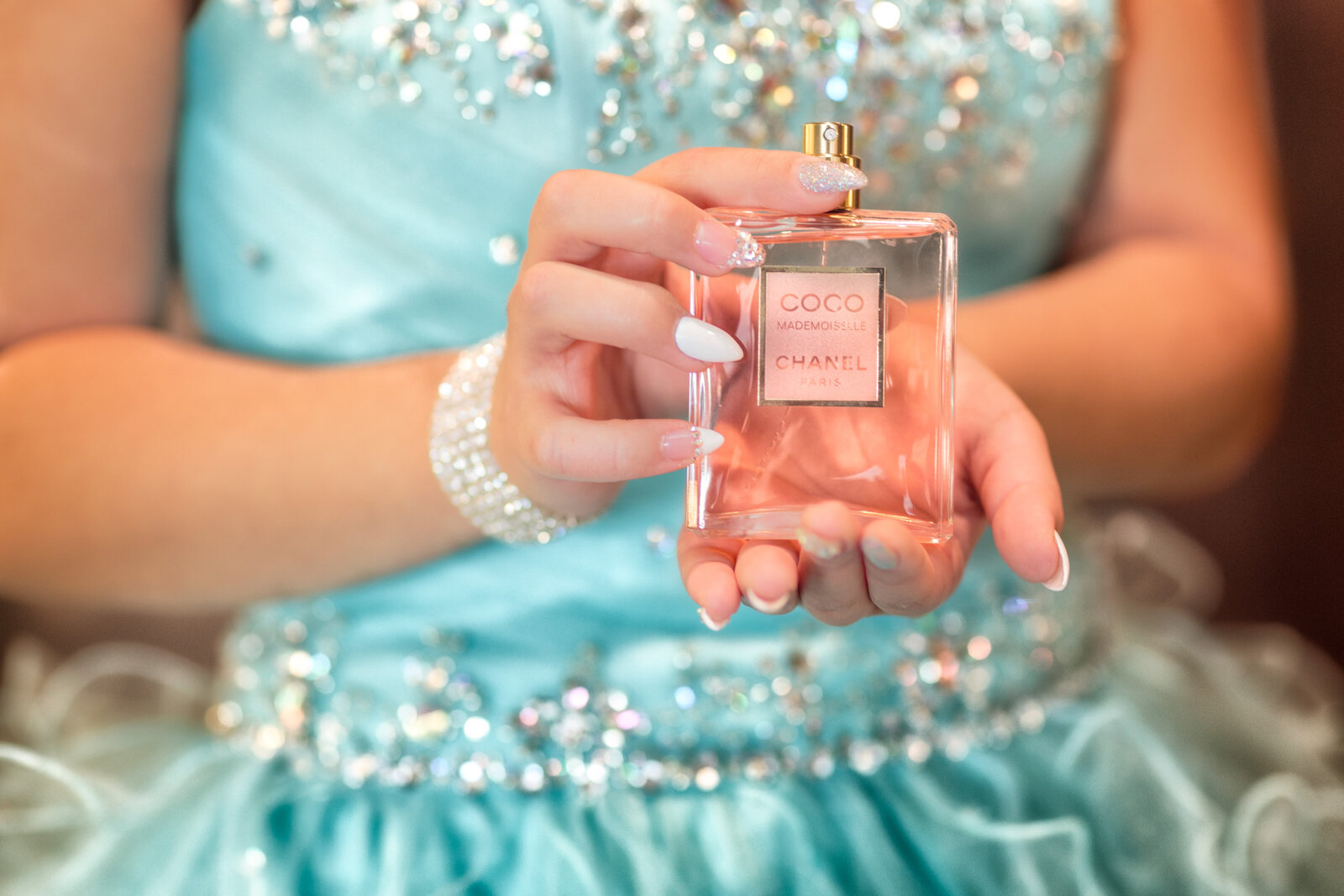 A detailed shot of Yarelis holding her elegant perfume bottle during her quinceañera celebration at the Hilton Cleveland Downtown. Capturing the little details that make her day special.