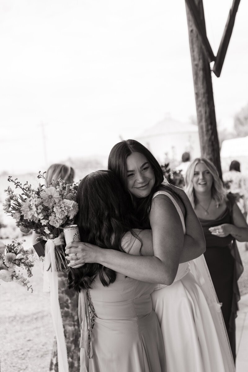 Bride hugging bridesmaid taken by idaho wedding photographer