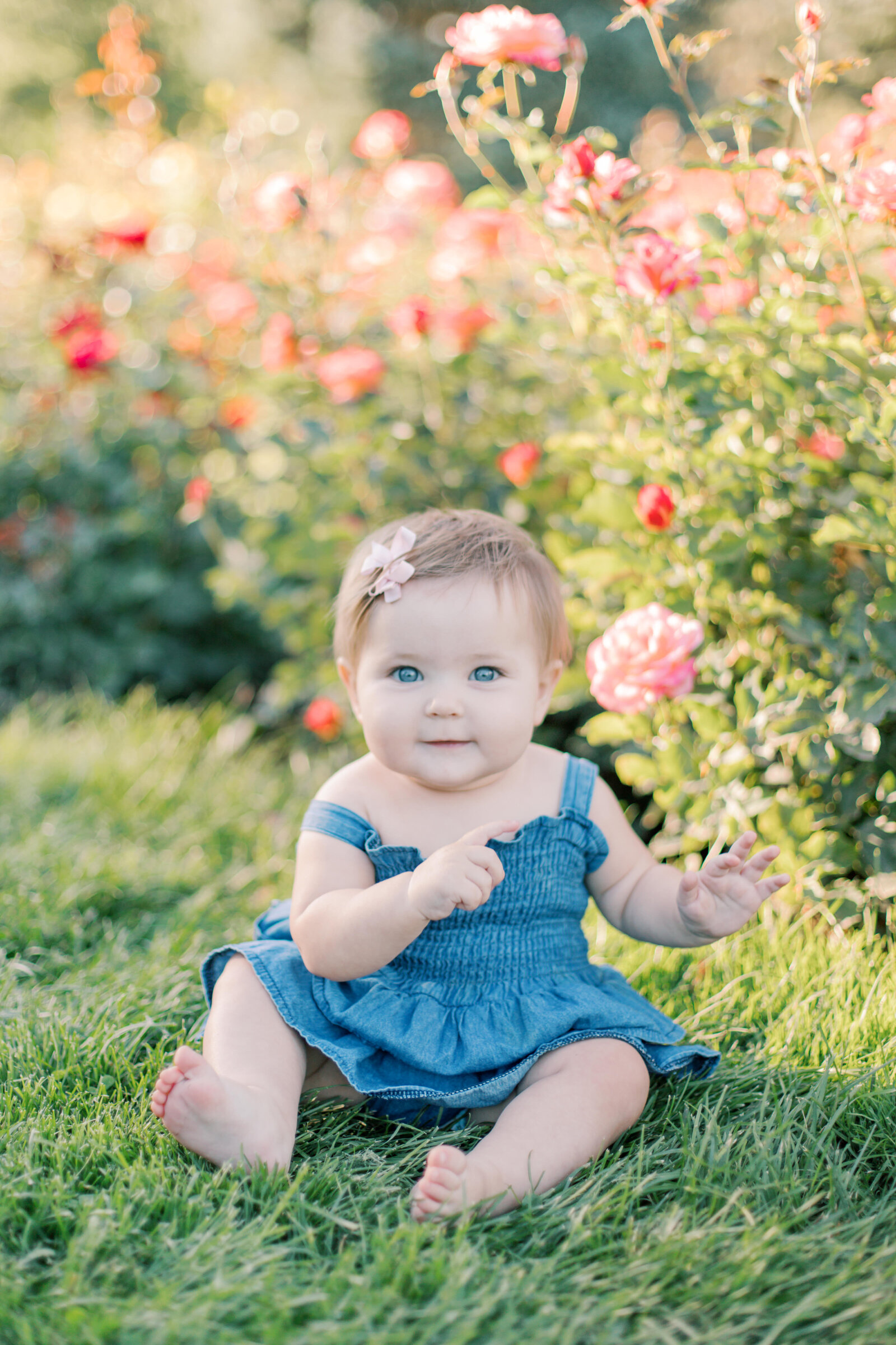 daughter sitting next to roses by family photographers spokane