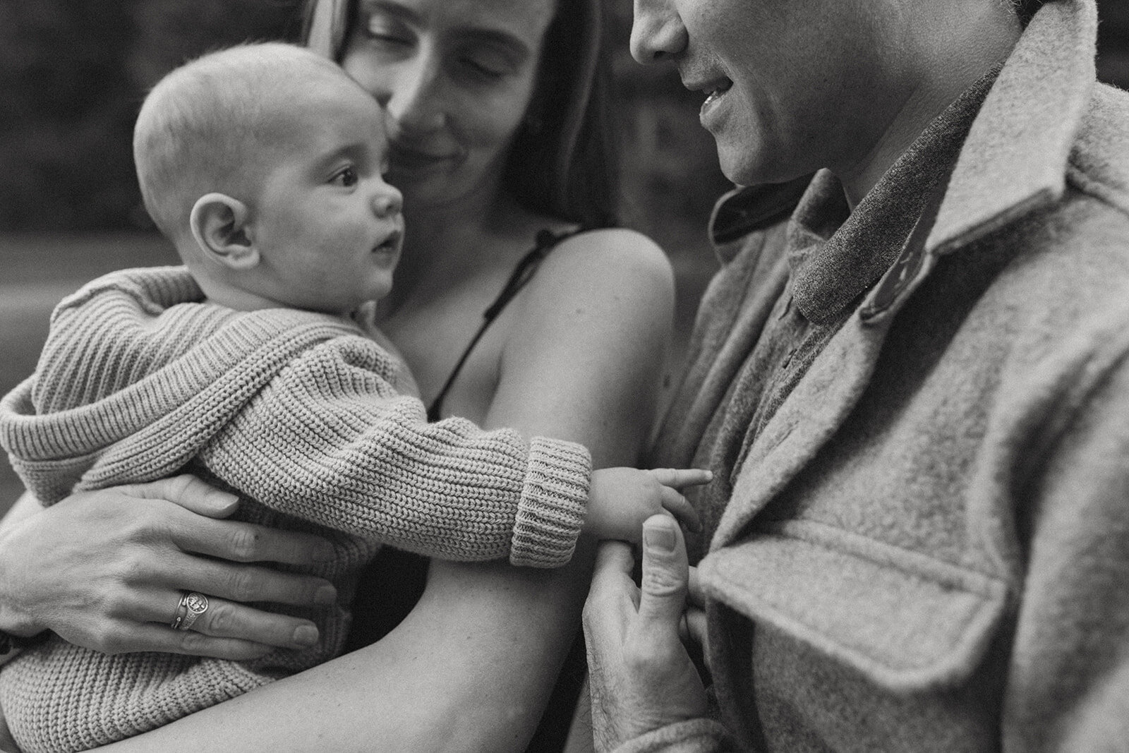 young child holds hands with dad during family session in fernie