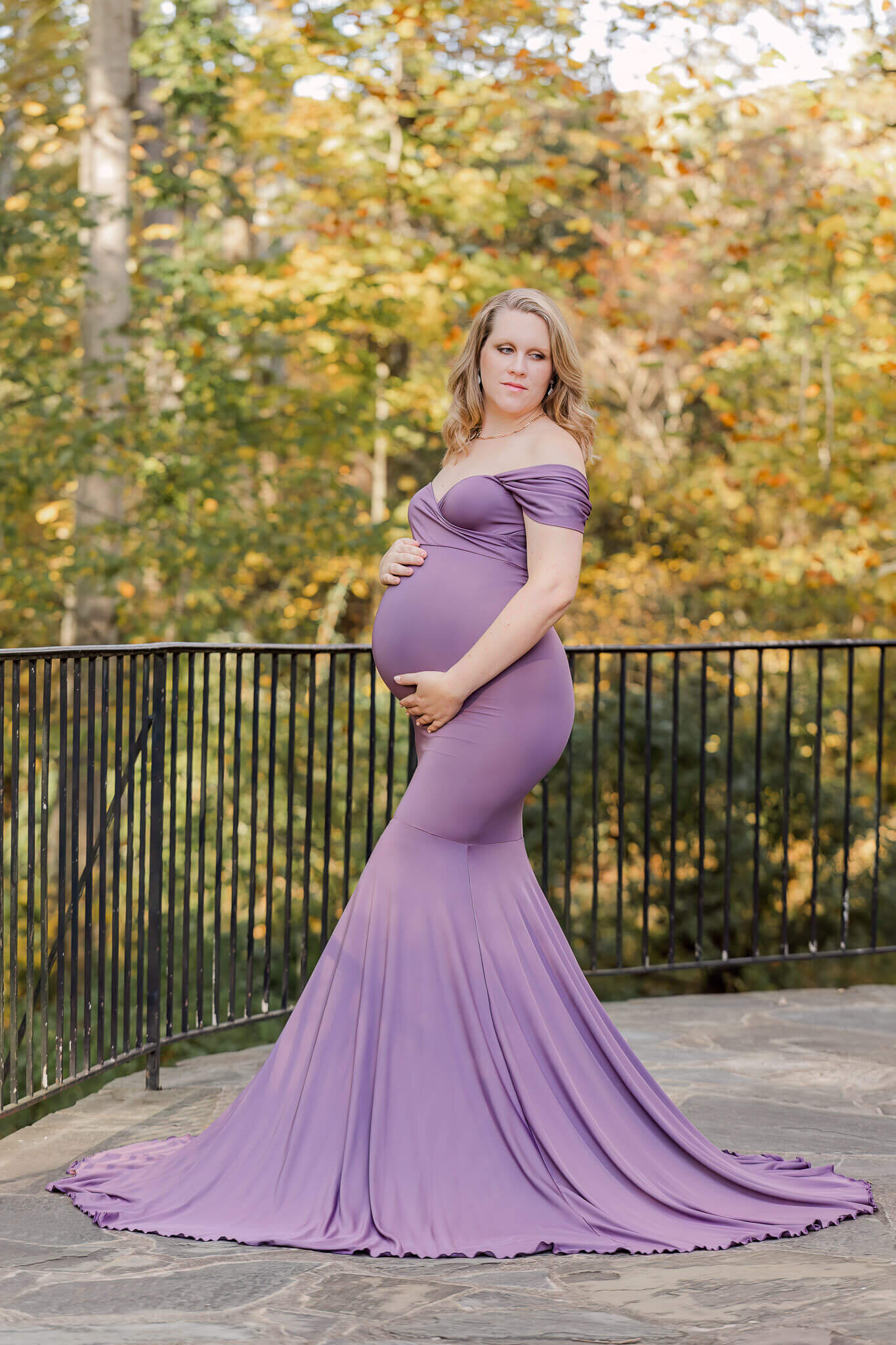 A mom-to-be wearing a purple dress for her maternity session with Centreville maternity photographer Melissa Driggers.