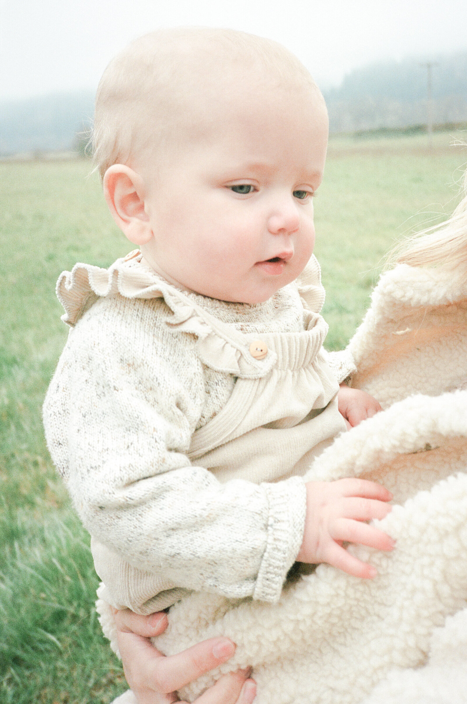 Mother holding baby girl in a field on Sauvie Island in Portland, Oregon.