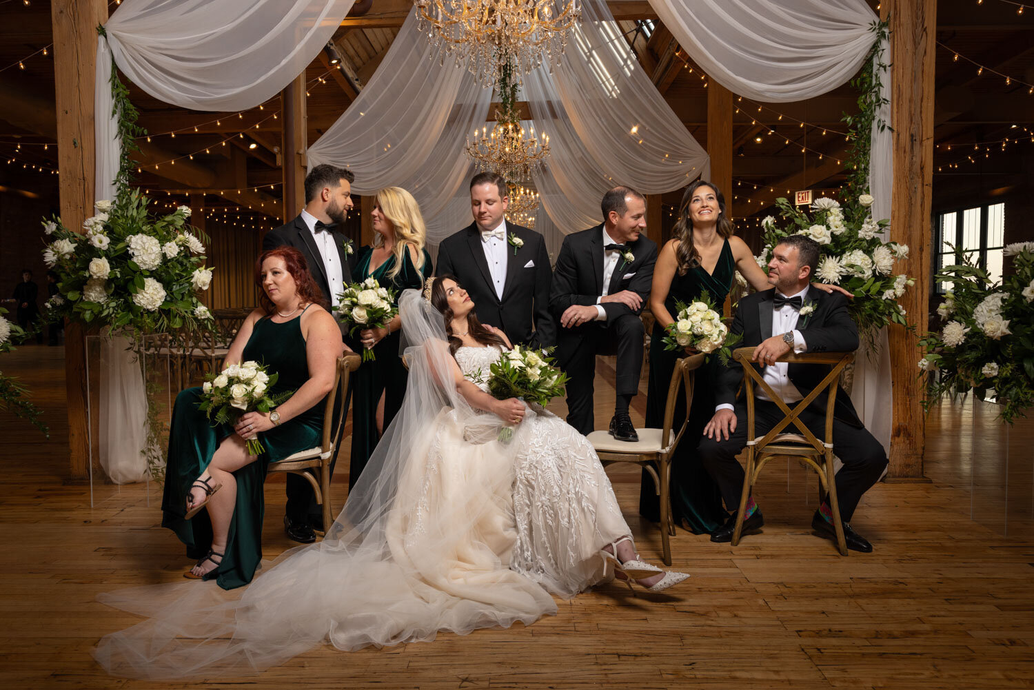 A bride and groom are posing for a picture with their wedding party.