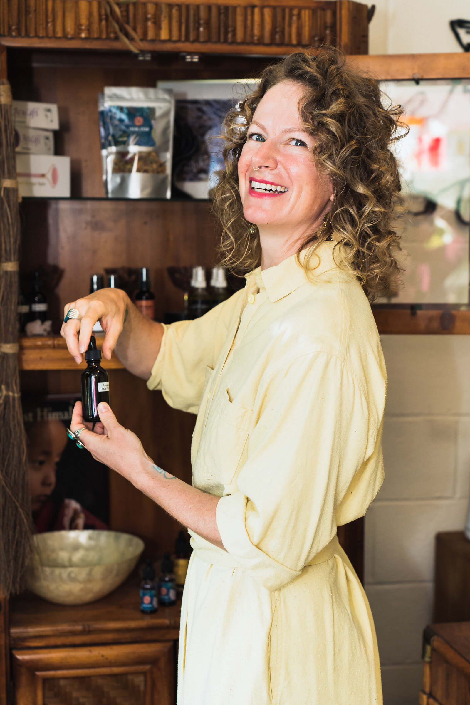 small business owner holds an essence oil and smiles