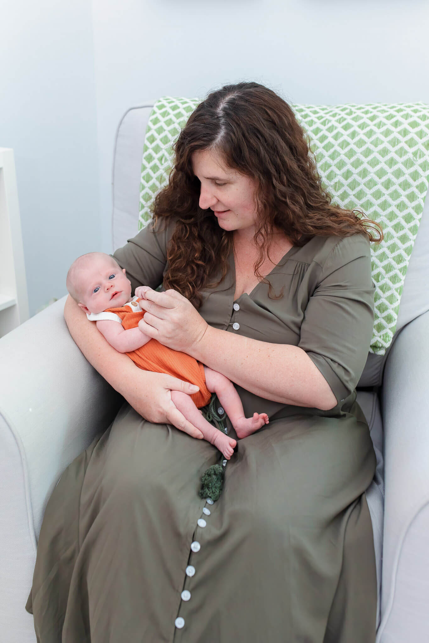 A mom holding her newborn son in the nursery.