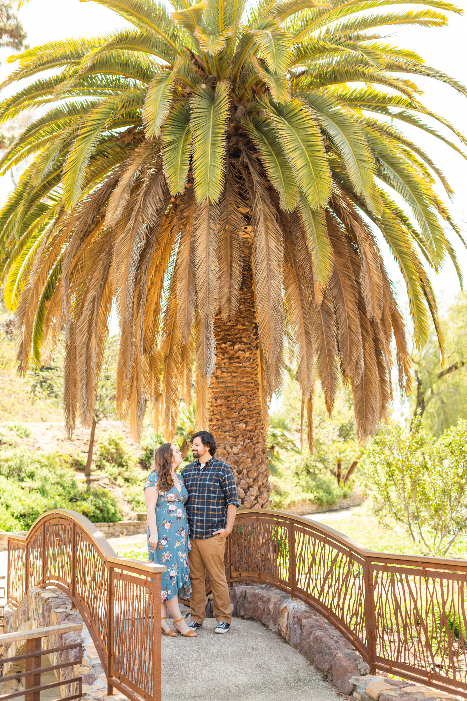 An engaged couple poses for photos in a garden in Los Angeles, Ca.