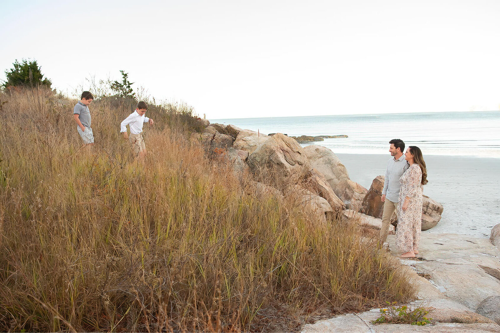 The parents watch their kids run down a bank during a photo session at Wingaersheek Beach.