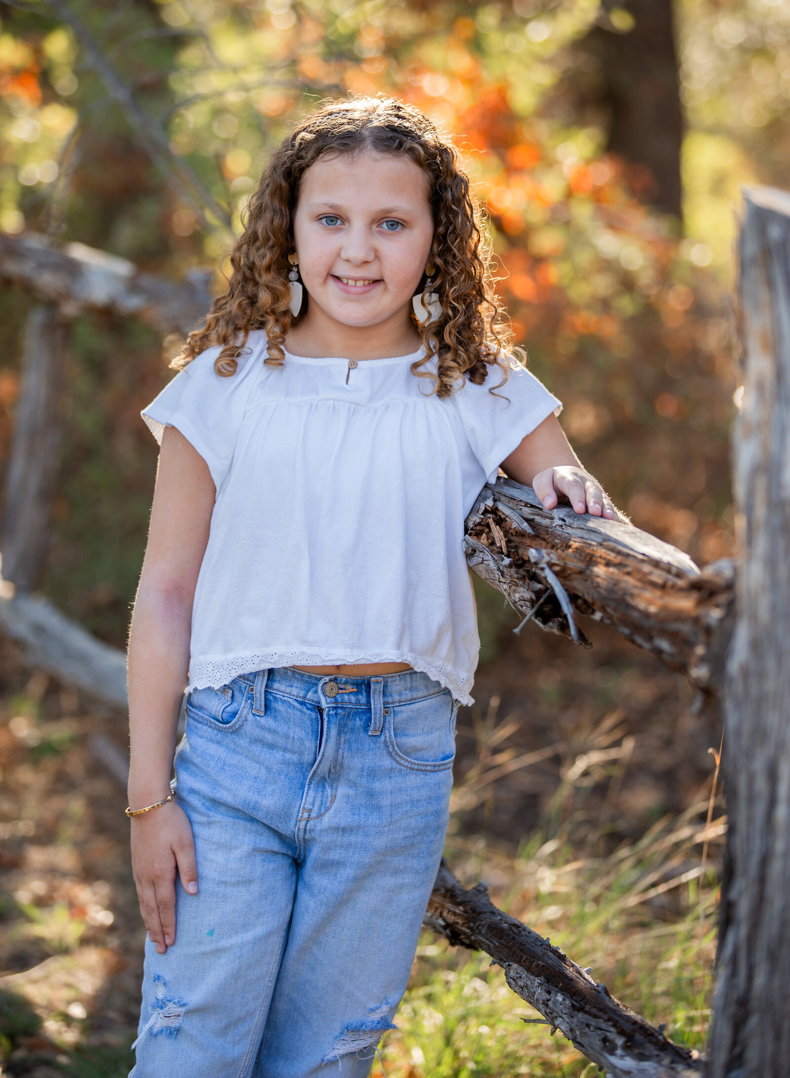 girl smiling by fence