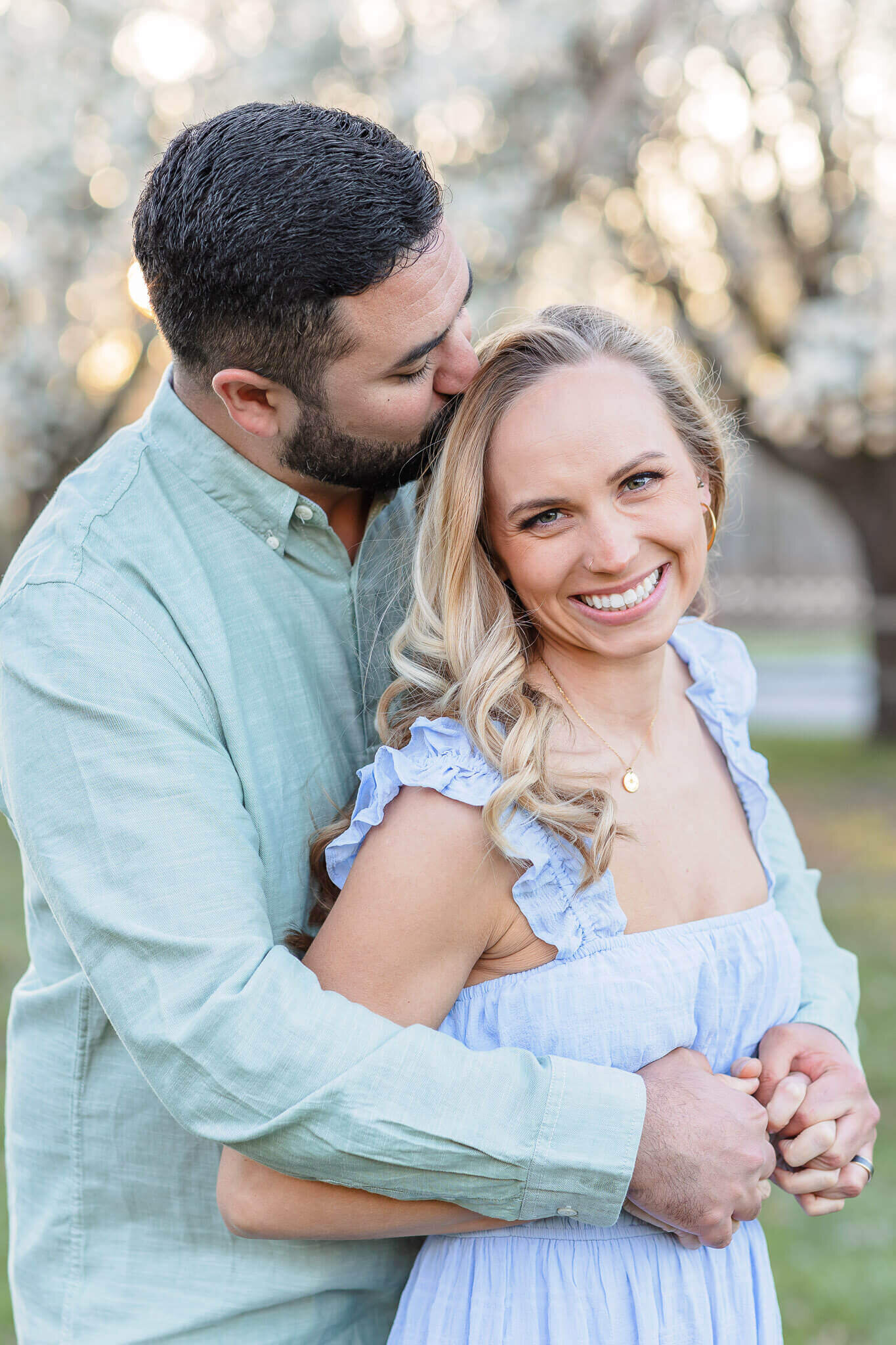 A couple holding each other at a park in the spring.