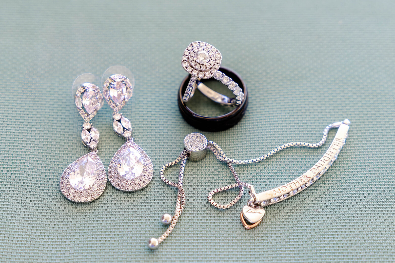 Close-up of stunning bridal jewelry including earrings, bracelet, and wedding rings, elegantly displayed for an Ocean Isle Beach, NC wedding.