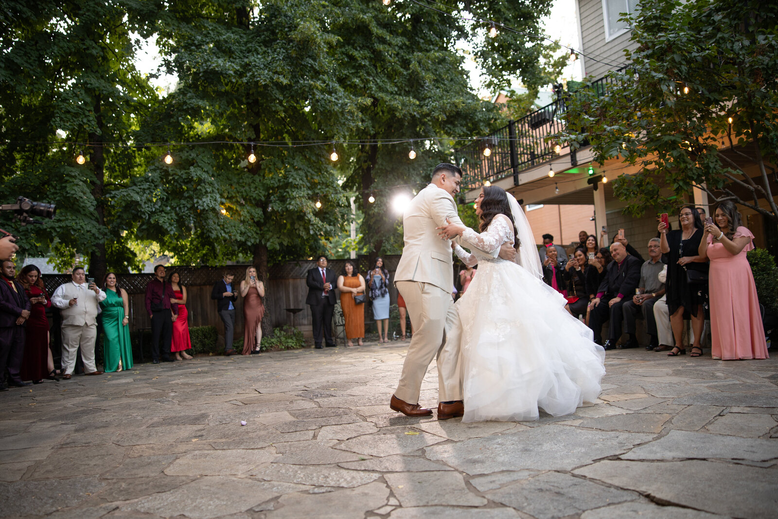 Bride and groom dancing in the courtyard of forest house lodge, sacramento wedding venue.