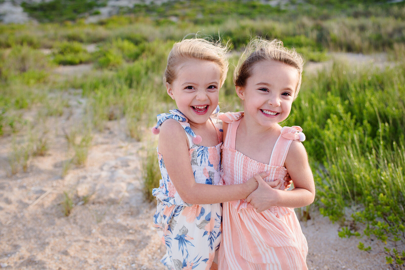 Twin girls smiling and laughing together at Guana Reserve Beach in Ponte Vedra, FL.