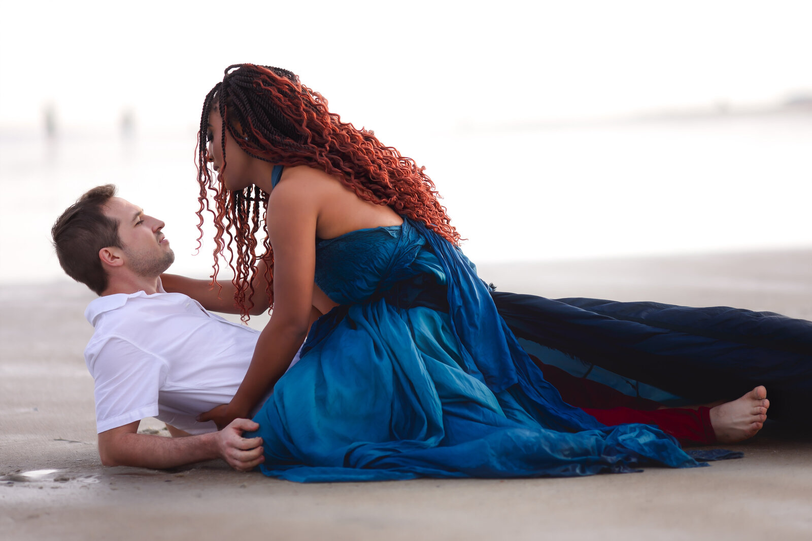 Savannah Georgia Boudoir and Glamour couple in blue parachute gown on beach laying down in sand