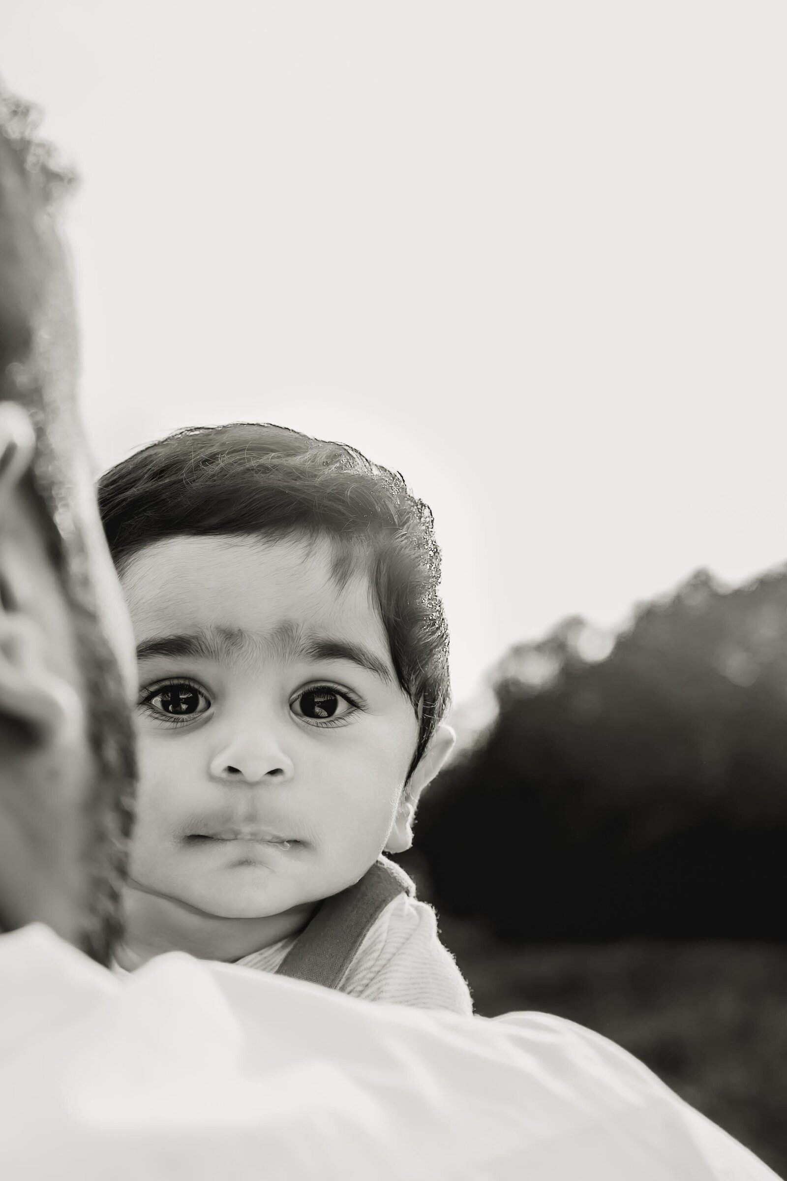 baby peeking over a dad's shoulder