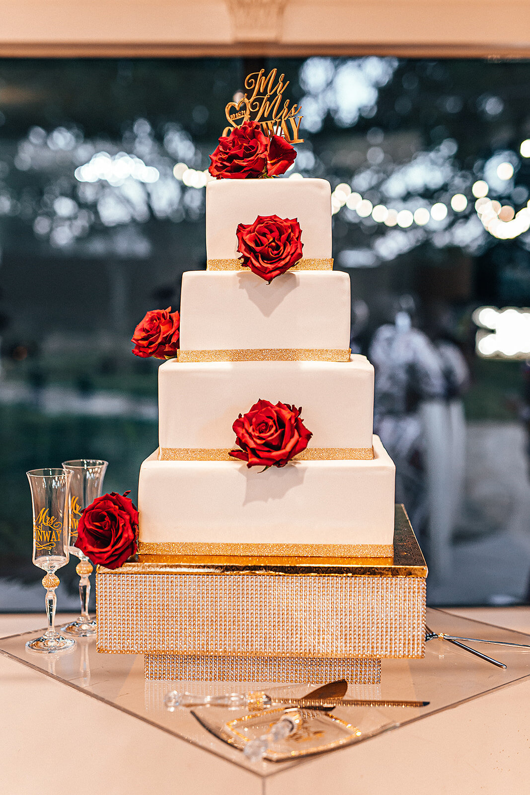 Four tier white and gold square wedding cake  with red roses