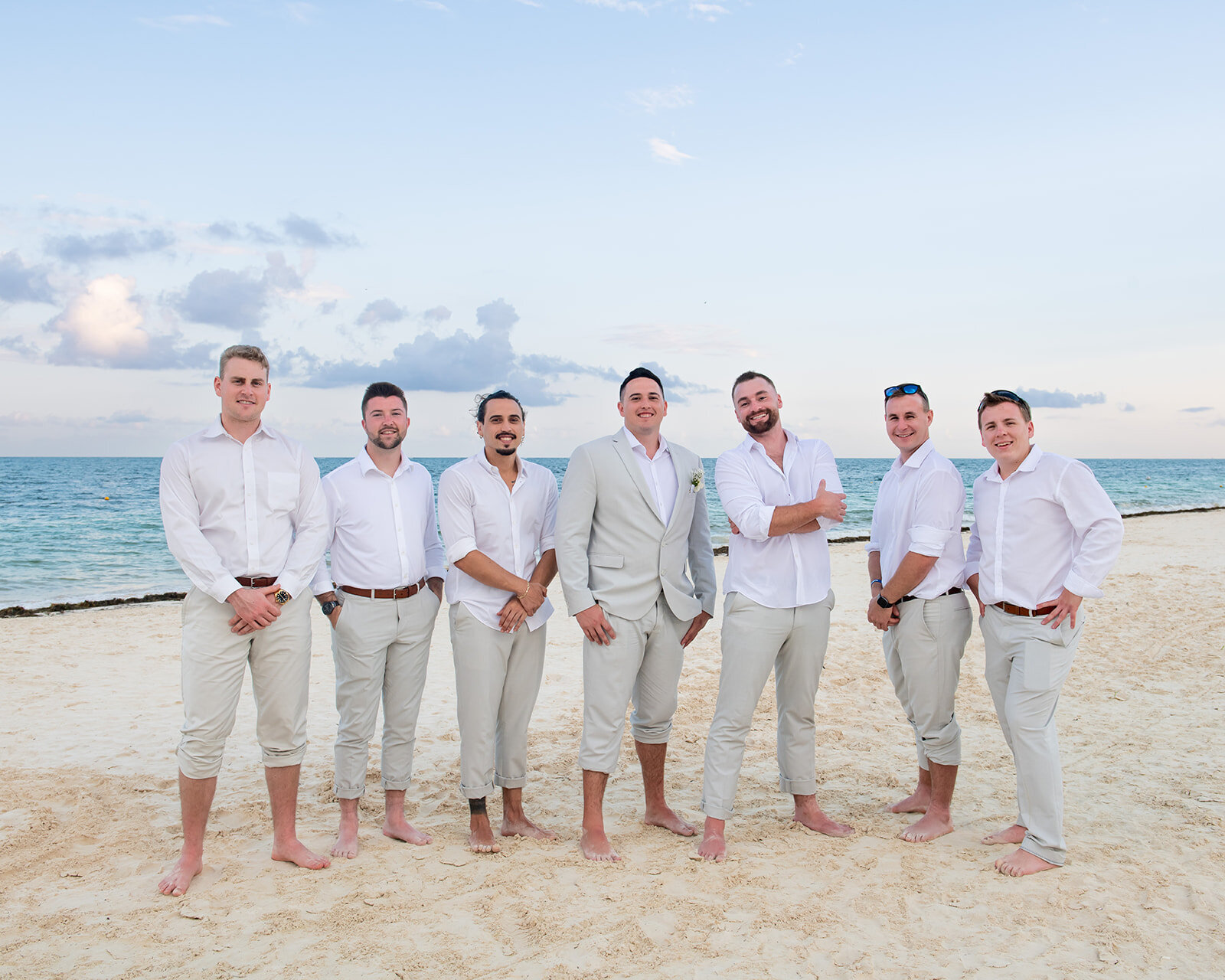 A candid moment of the groomsmen having fun on the beach before the wedding ceremony, captured during a destination wedding by CMH Studios