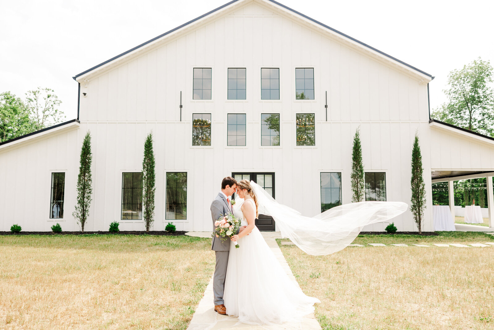 a bride and groom posing together in front of their wedding venue