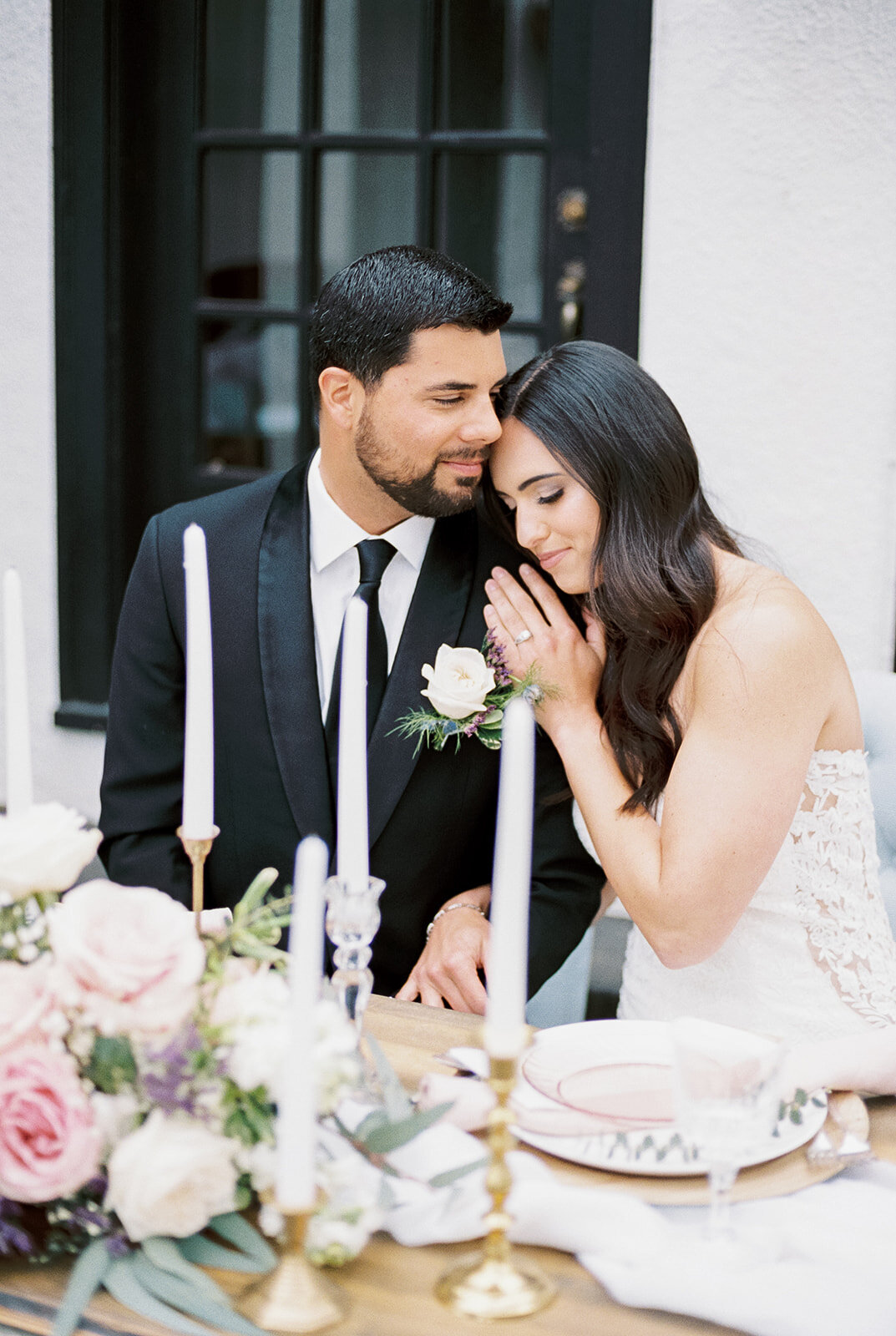 Bride and groom cuddling at head table at Cottage at Riverbend Wedding by the Best Boise Wedding Photographers