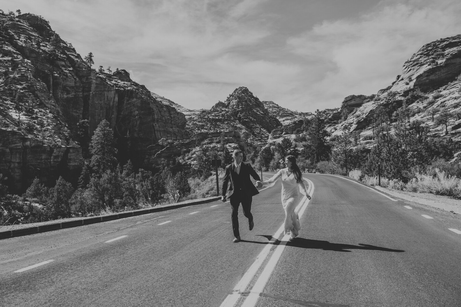 a couple in love running through the mountains in zion national park, elopement