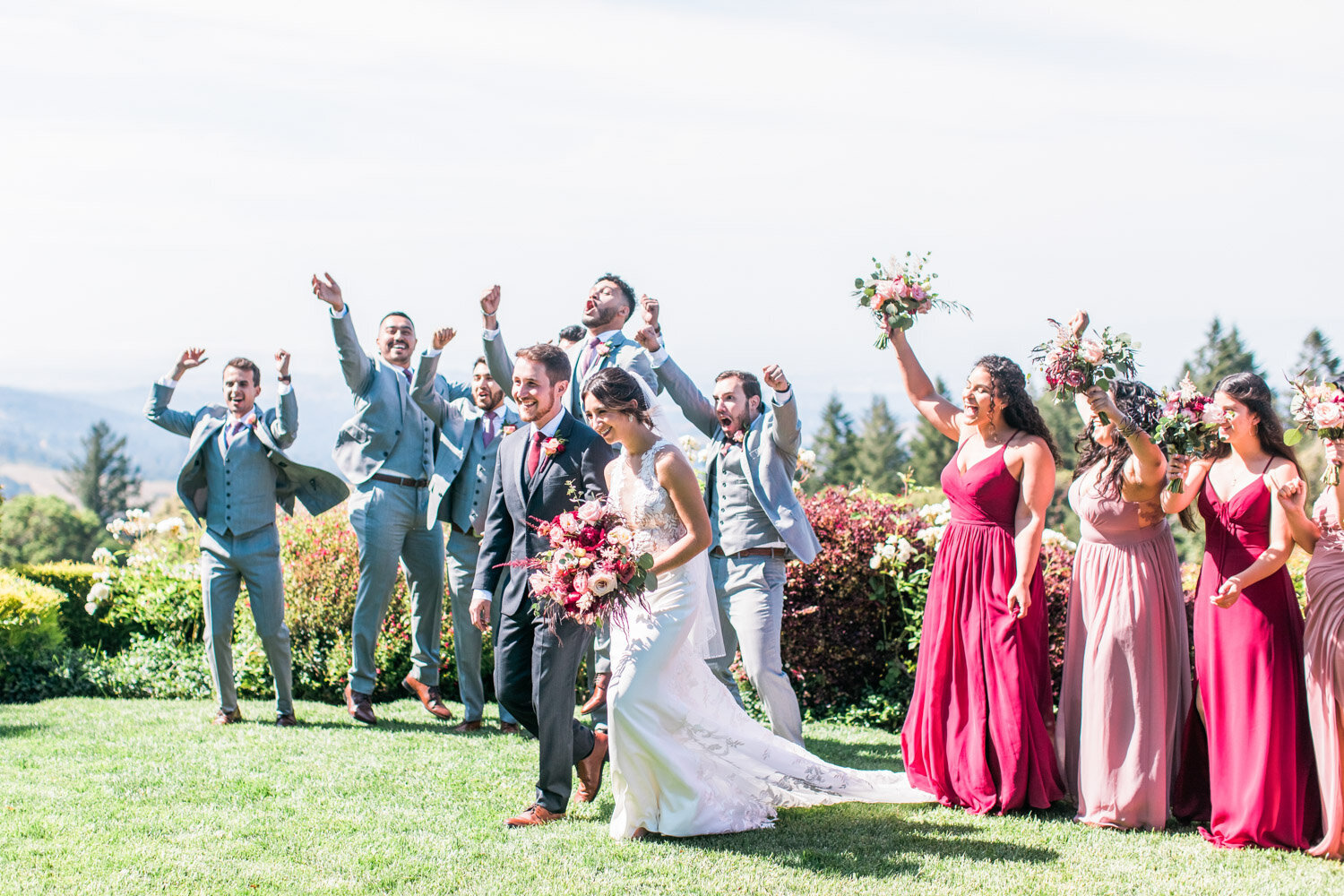 Bride and groom walking with joyful wedding party