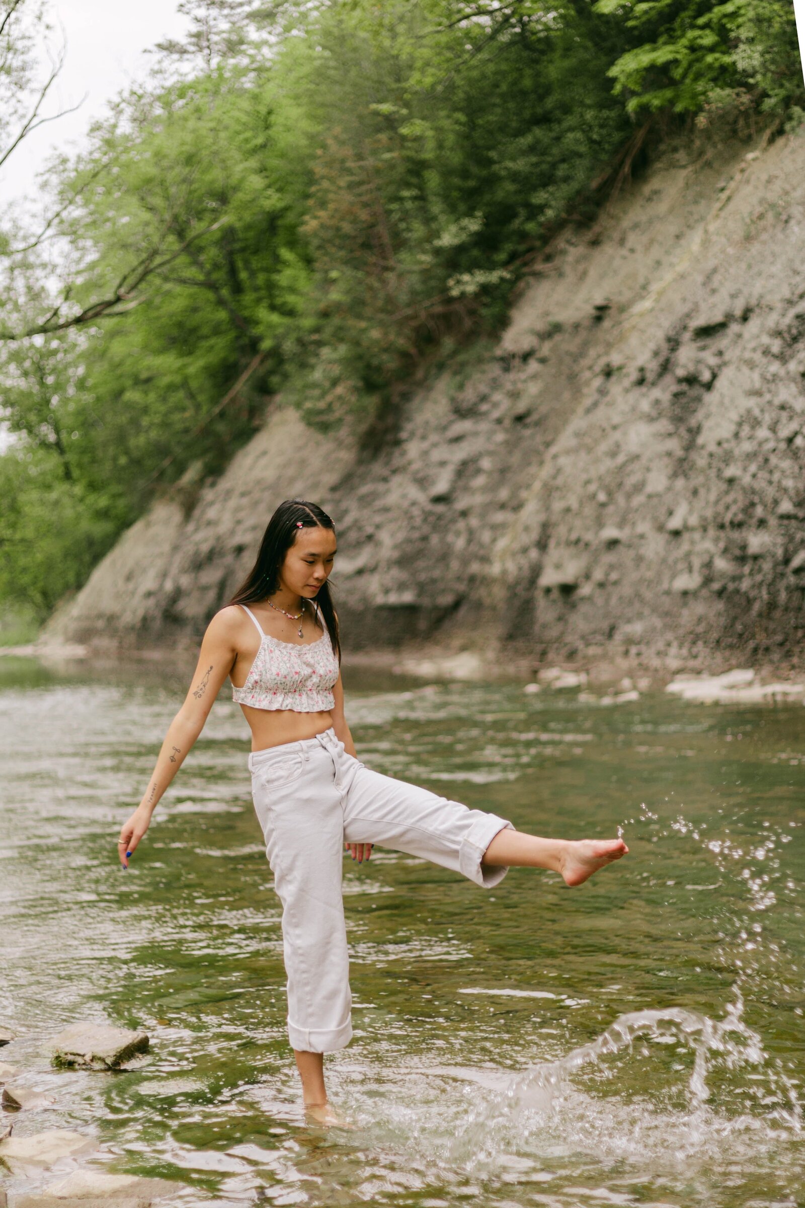 woman walking on rocks by river