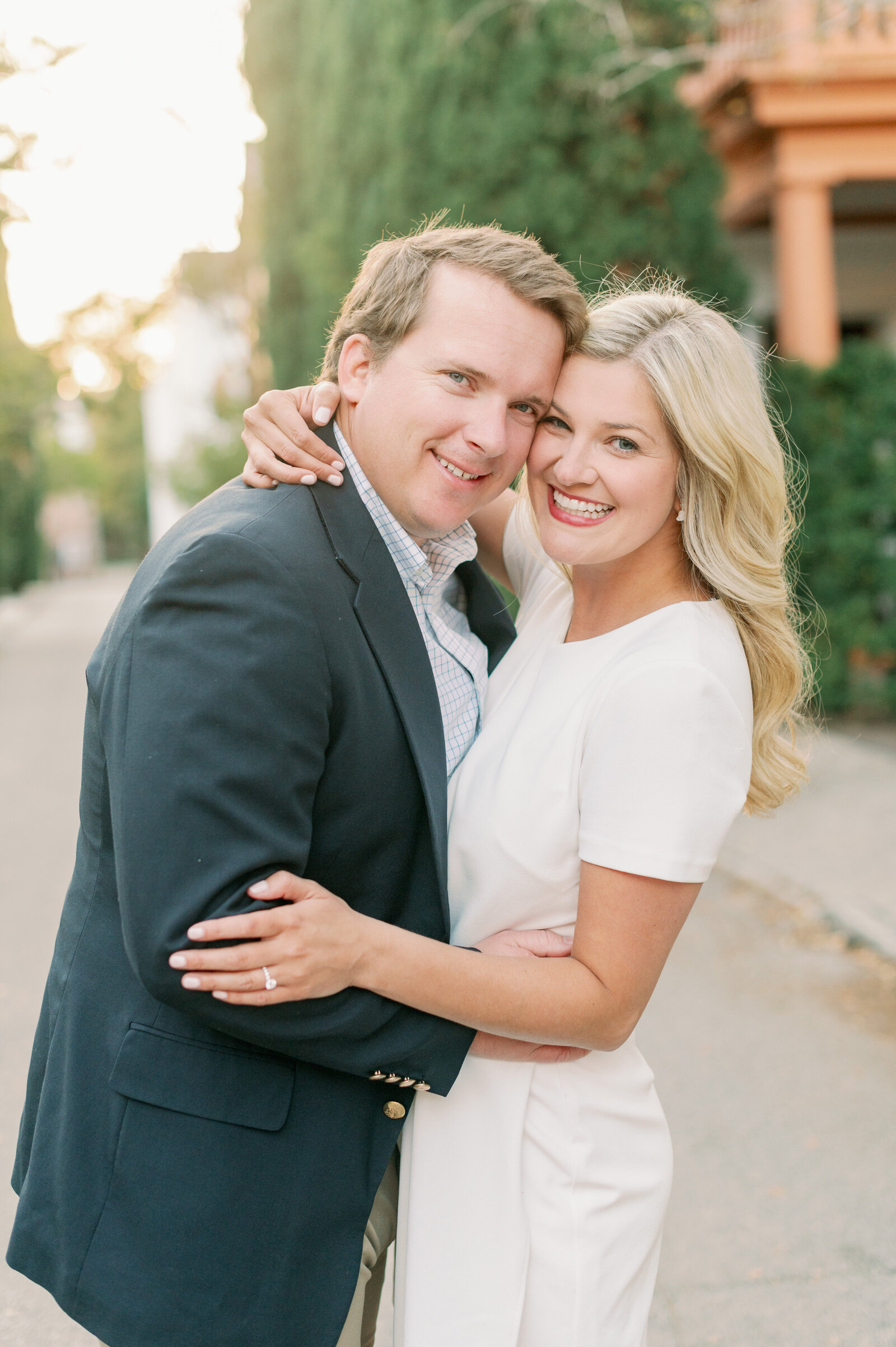 Couple hugs and smiles at the camera during their historic charleston engagement session