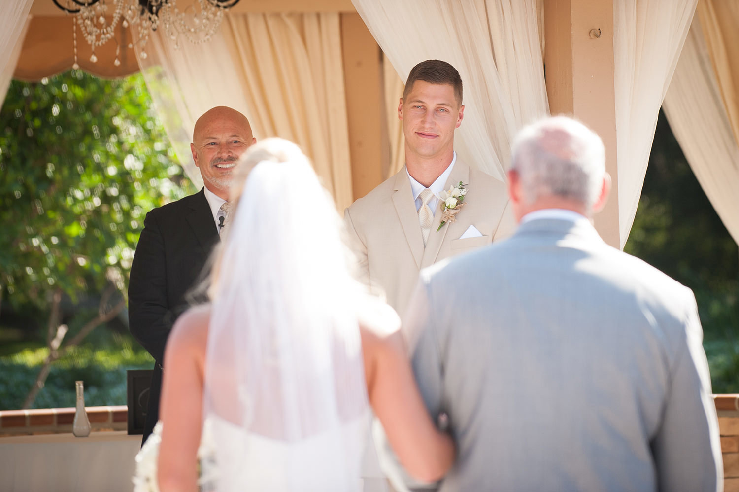 groom crying at bride walking down the aisle
