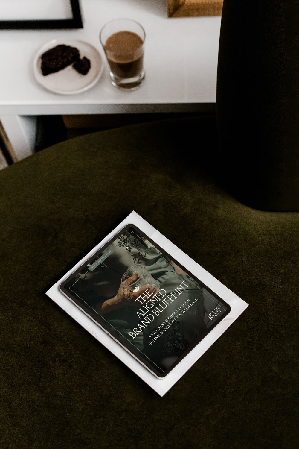 Tablet displaying the Aligned Brand Blueprint resting on a velvet sofa, showcasing holistic branding strategies for entrepreneurs.