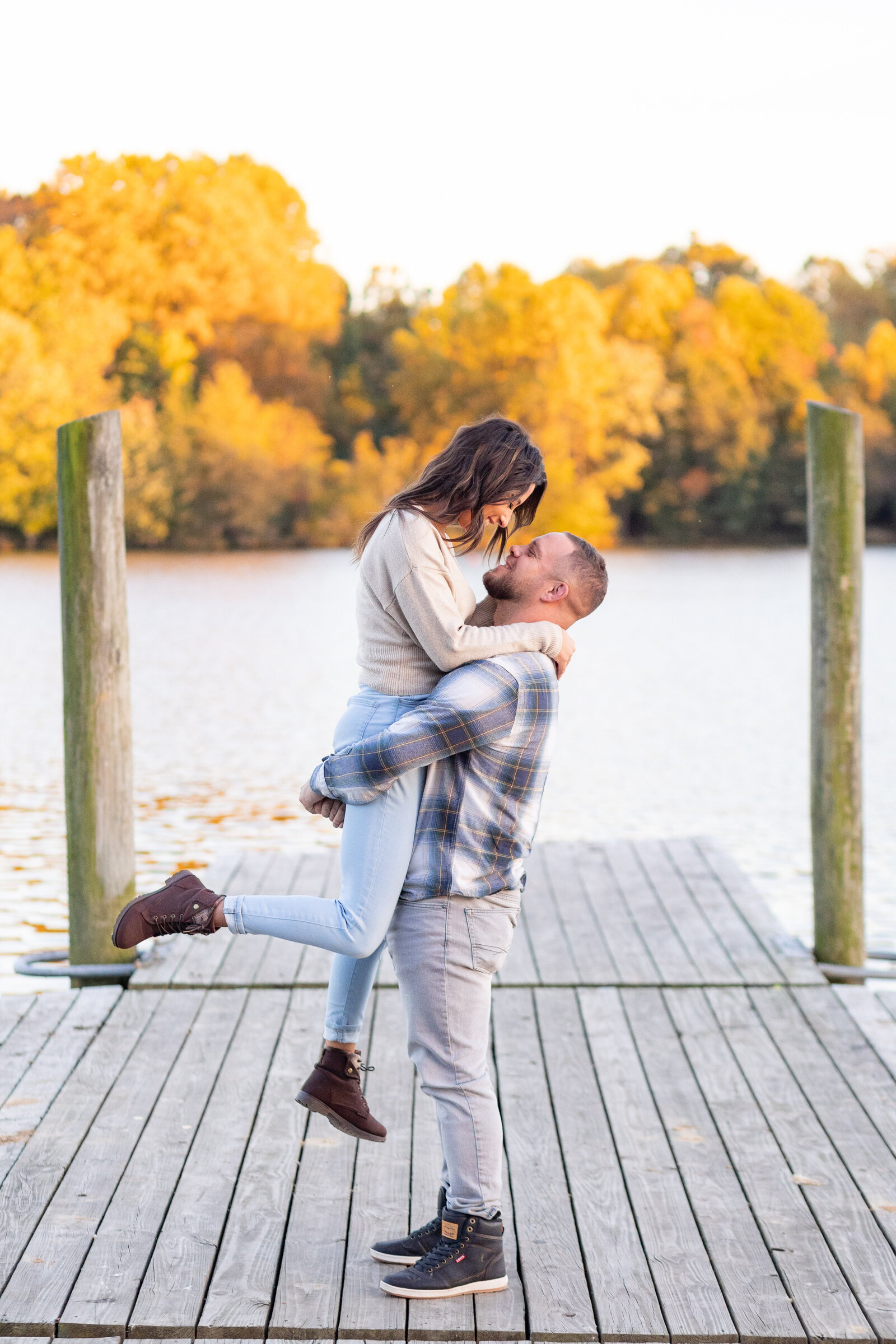 tyler state park engagement couple on bridge kicking foot in air