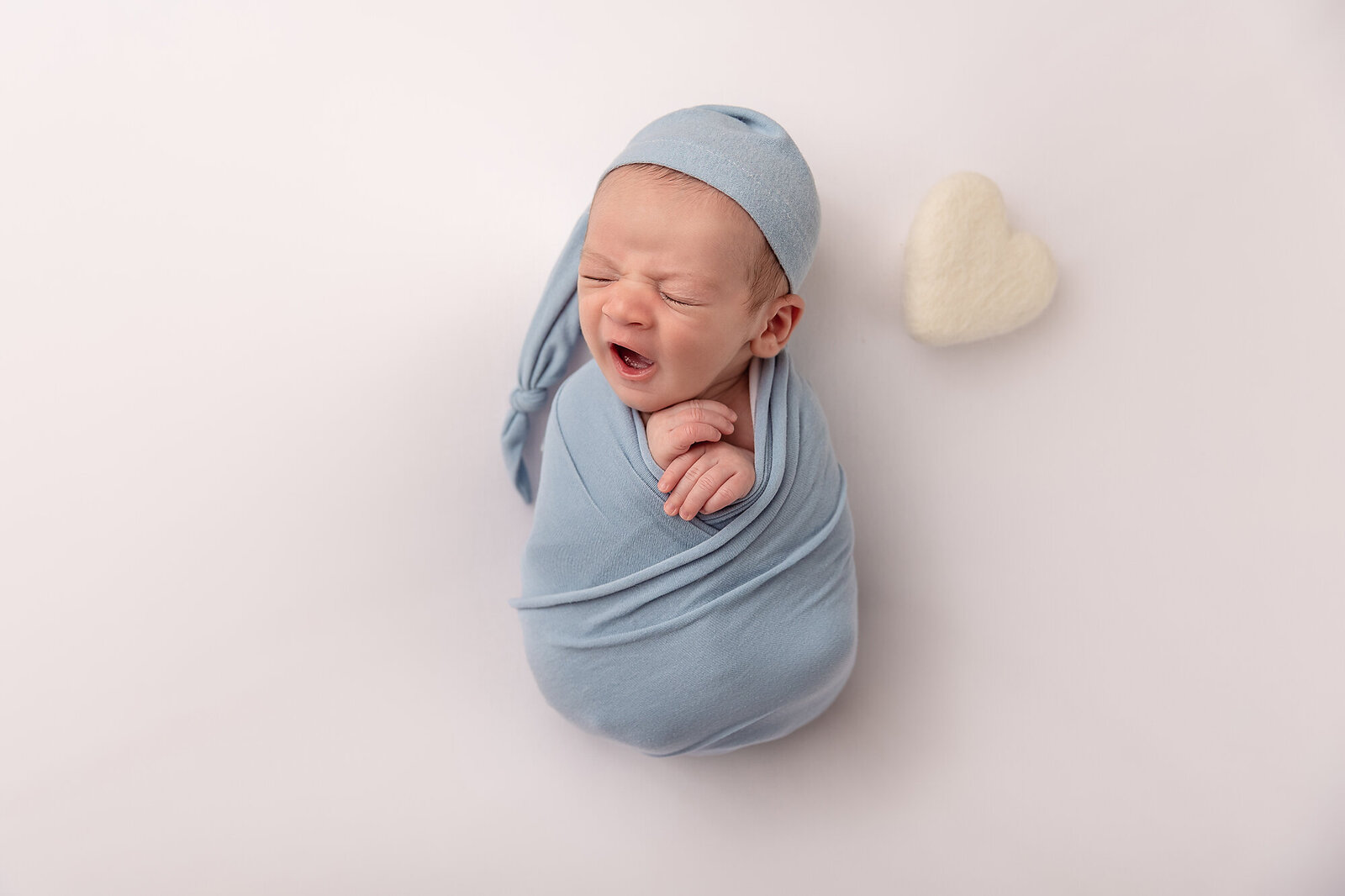 baby yawning in blue swaddle by Newborn Photography Bucks County PA