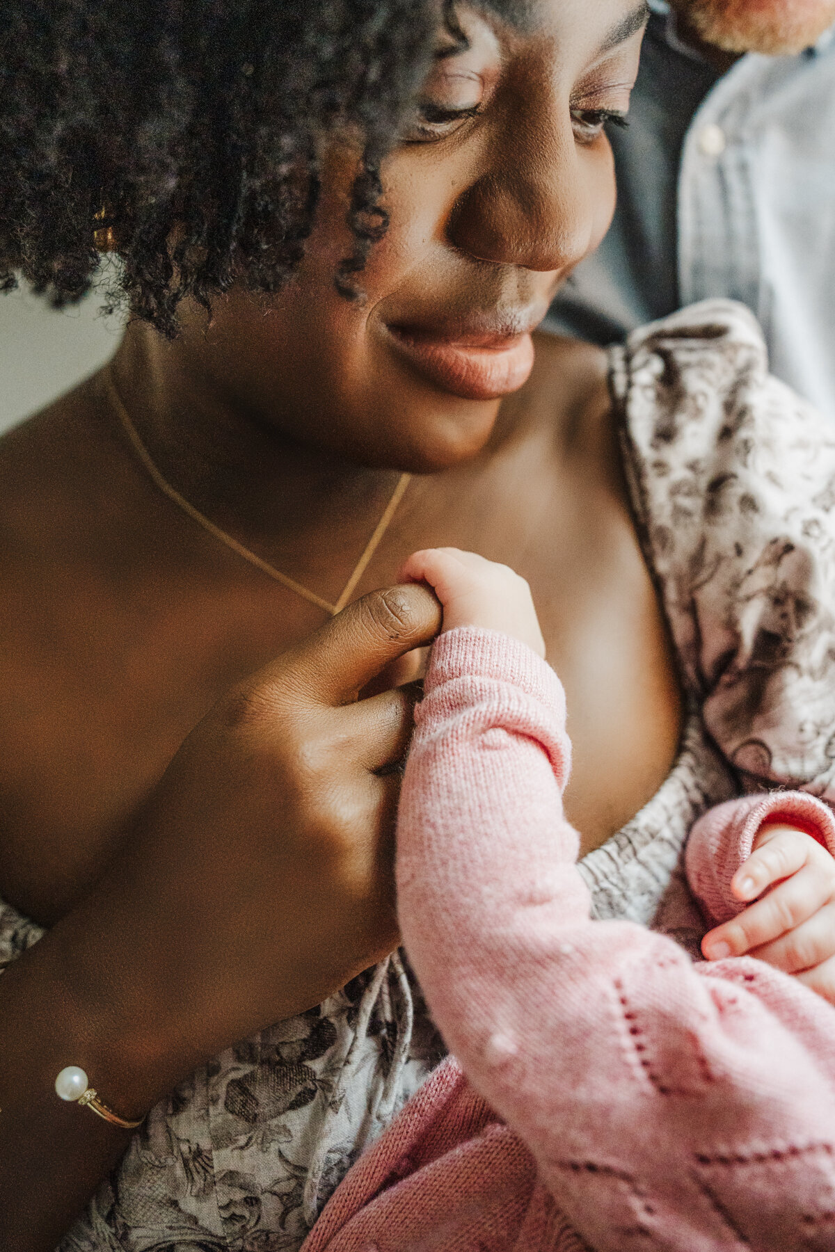 close up of a mother holding infant daughters hand