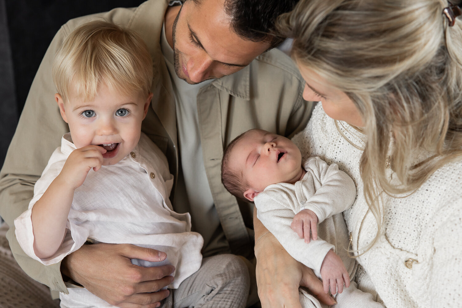 Gezin van vier tijdens een newbornshoot. Close up van een knuffelmoment.