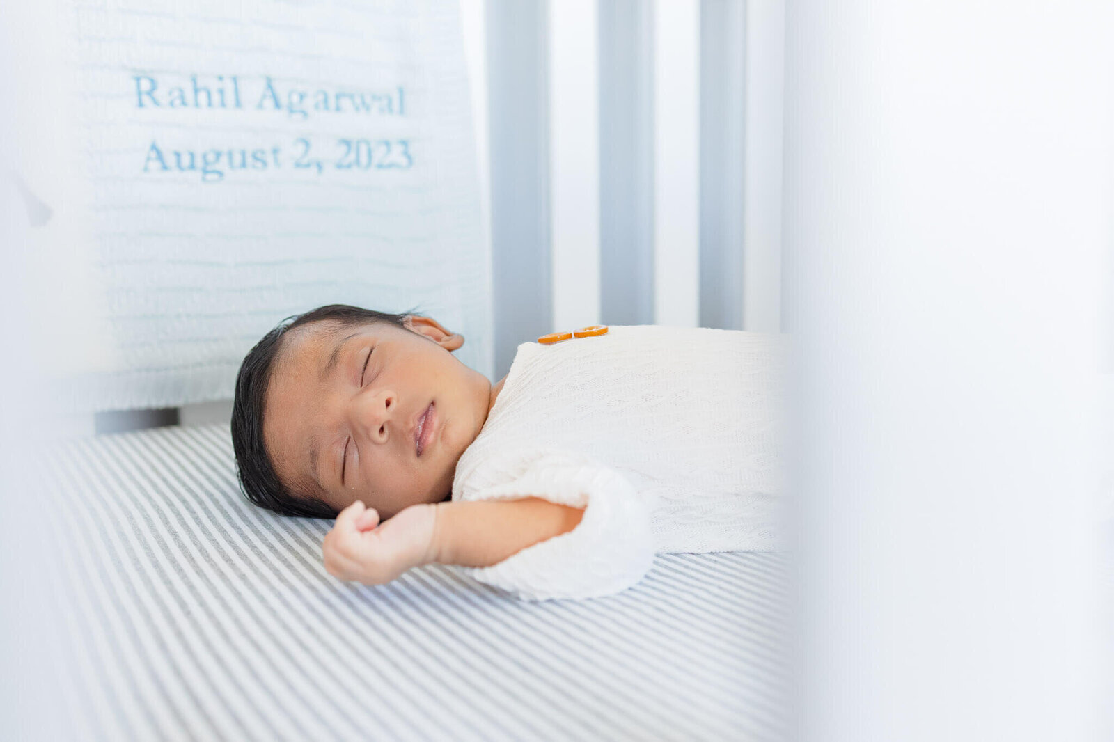 A newborn boy sleeping in his crib.