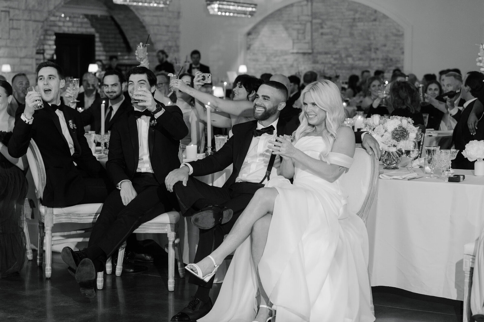 bride and groom laughing and clapping while they listen to wedding toasts at Grbic Events, a wedding venue in St. Louis