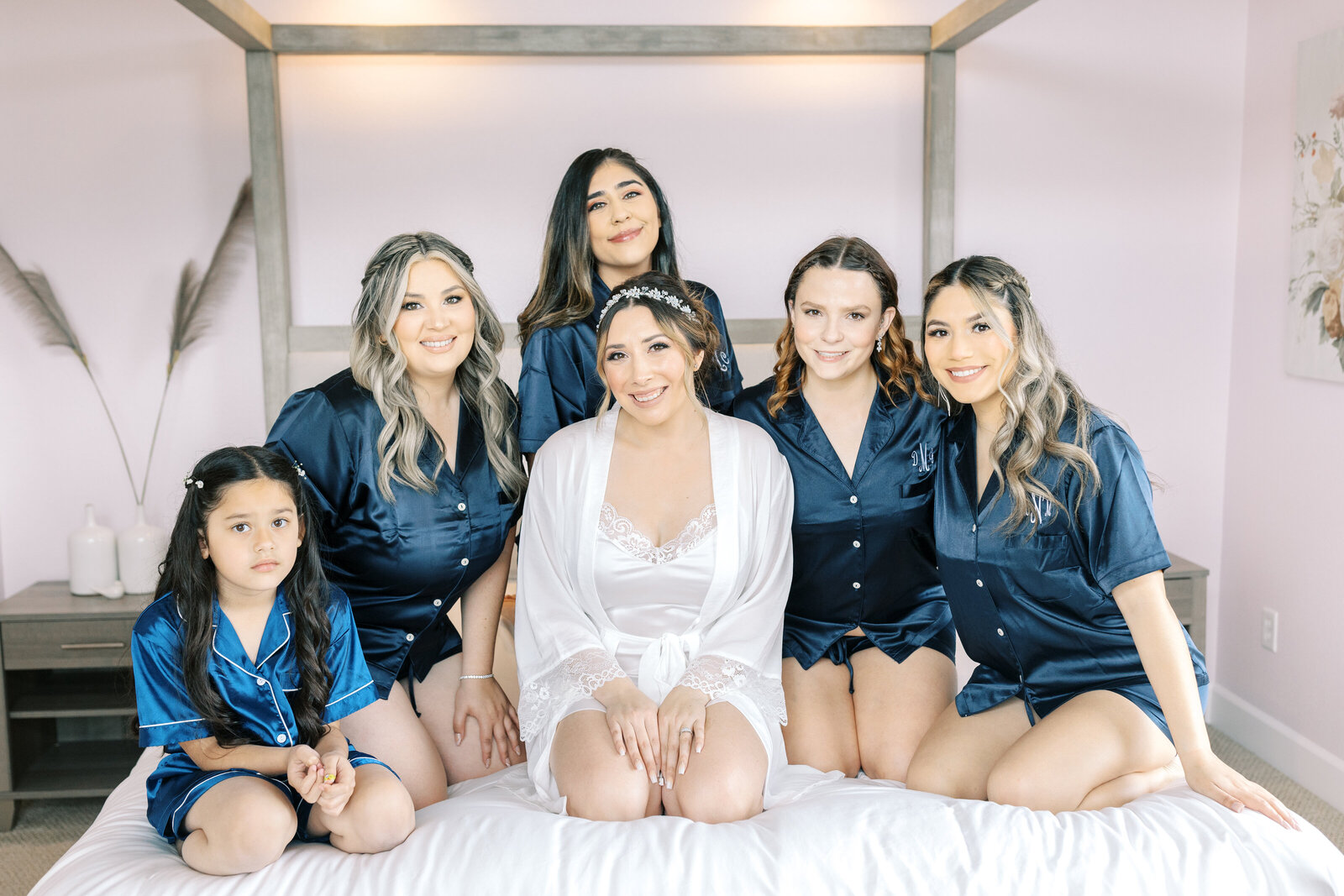 sacramento wedding photographer photographs bridesmaids in bridesmaids pajamas sitting on a bed in the bridal suite at Wolfe Heights for wedding pictures