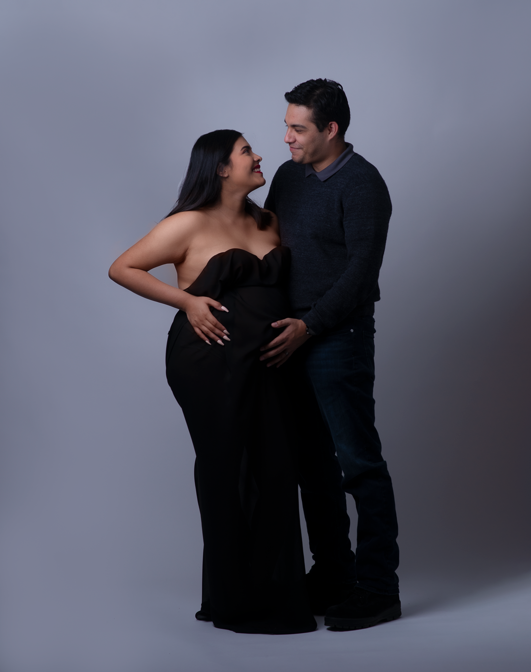 Maryland Maternity Photographer - Couples Maternity Pose looking at eaching outher
