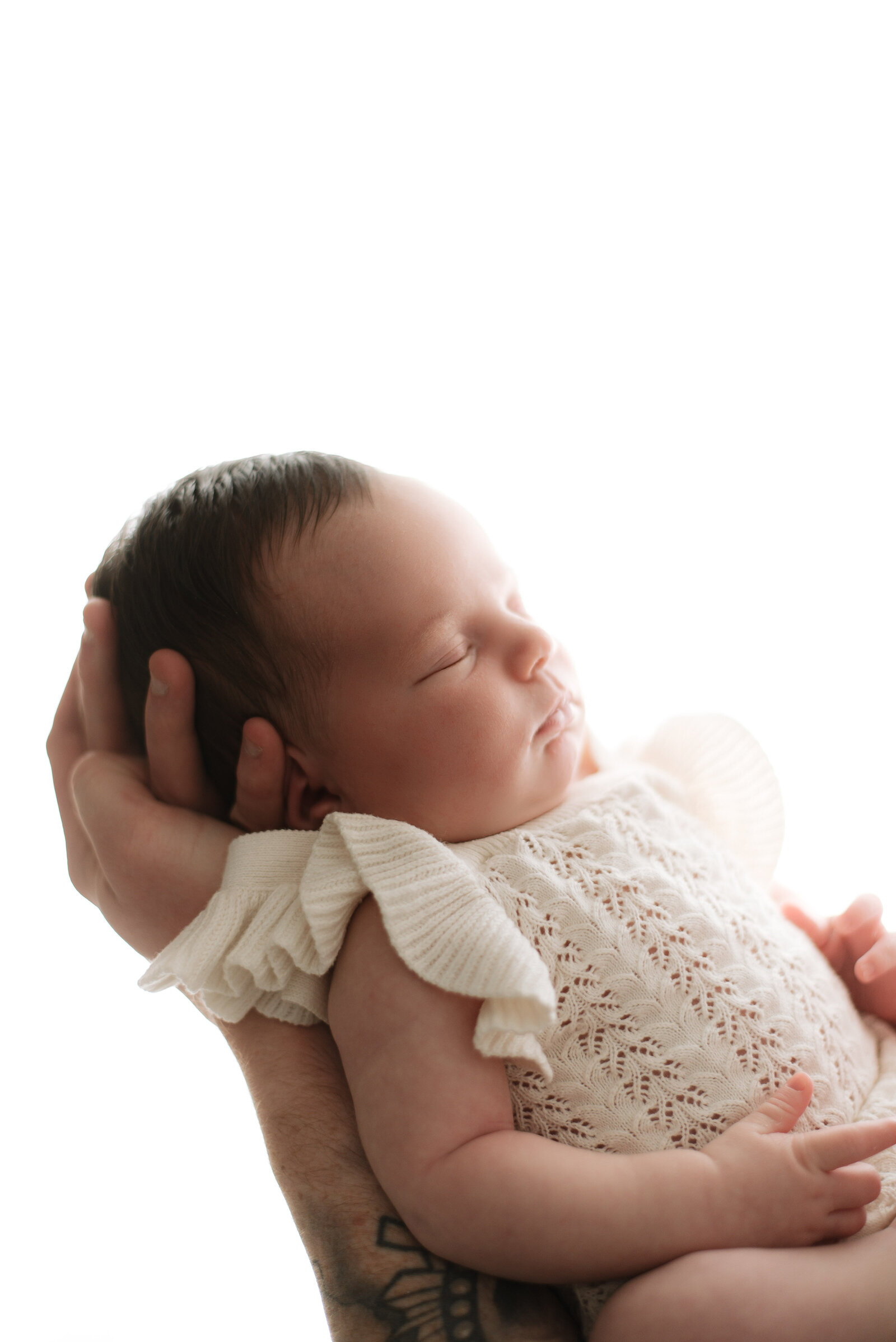 Baby girl sleeping in dads arms at billingshurst newborn photoshoot