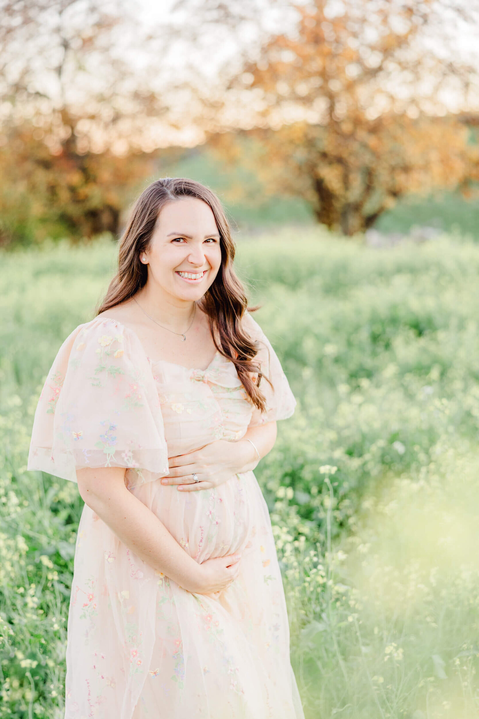 Pregnant mom laughs while holding her baby bump